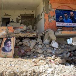 Niños pasan junto a un edificio destruido con las imágenes de Hassan Nasrallah, líder del movimiento chií libanés Hezbolá, asesinado, y otros hombres que murieron en el conflicto con Israel, en la aldea de Aita al-Shaab, cerca de la frontera con Israel, en el sur del Líbano. | Foto:Mahmoud Zayyat / AFP