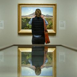 Un visitante observa las obras de arte (de izq. a der.) del pintor mexicano José María Velasco, "Roca en el Cerro de Atzacoalco" (1874), "La Fábrica Textil de La Carolina, Puebla" (1887) y "Pico de Orizaba" (1986), durante una sesión fotográfica para la exposición "Una Vista de México" en la National Gallery, en el centro de Londres. | Foto:Ben Stansall / AFP