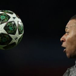 El delantero francés del Real Madrid, Kylian Mbappé, se concentra en la pelota durante el partido de ida de los cuartos de final de la UEFA Champions League entre el Arsenal y el Real Madrid, en el Emirates Stadium, en Londres. | Foto:Adrian Dennis / AFP