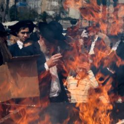 Hombres judíos ultraortodoxos queman alimentos leudados como preparación final antes del inicio de la festividad judía de la Pascua (Pésaj) al atardecer, en la ciudad de Bnei Brak, en el centro de Israel. | Foto:JACK GUEZ / AFP
