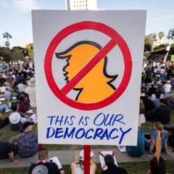 Un manifestante sostiene un cartel durante la protesta nacional "¡Manos Fuera!" contra el presidente estadounidense Donald Trump y su asesor, el director ejecutivo de Tesla, Elon Musk, en el centro de Los Ángeles. | Foto:ETIENNE LAURENT / AFP