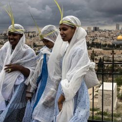 Fieles cristianos posan para fotografías frente a la Cúpula de la Roca mientras marchan por una calle durante la tradicional procesión del Domingo de Ramos en el Monte de los Olivos en Jerusalén. | Foto:JOHN WESSELS / AFP