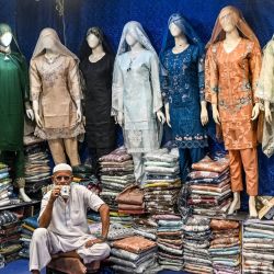 Vendedores esperan a clientes en su tienda en un mercado de Karachi, Pakistán. | Foto:RIZWAN TABASSUM / AFP