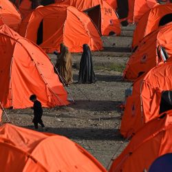 Mujeres refugiadas afganas caminan entre tiendas de campaña tras llegar desde Pakistán a un campamento improvisado cerca de la frontera entre Afganistán y Pakistán en Torkham, en la provincia de Nangarhar. | Foto:WAKIL KOHSAR / AFP