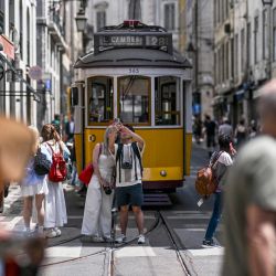 Peatones se toman selfies frente a un tranvía detenido en una calle del centro de Lisboa, durante un apagón masivo que afectó a toda la península Ibérica y al sur de Francia. | Foto:PATRICIA DE MELO MOREIRA / AFP