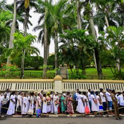 Devotos budistas hacen fila junto al personal de seguridad para entrar al Templo del Diente en Kandy, el último día de la exhibición pública de la reliquia sagrada del Diente de Buda. | Foto:ISHARA S. KODIKARA / AFP