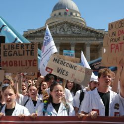 Estudiantes y médicos residentes portan pancartas y gritan consignas mientras protestan contra la propuesta de ley sobre "desiertos médicos", a favor de la abolición de la libertad de establecimiento y el restablecimiento de la Atención Ambulatoria Obligatoria (AAM), en la Plaza del Panteón de París. | Foto:Thomas Samson / AFP