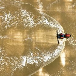 Vista aérea tomada con un dron de un trabajador conduciendo una máquina en una salina de Tianjin Changlu Haijing Group Co., Ltd., en Tianjin, en el norte de China. | Foto:Xinhua/Du Penghui