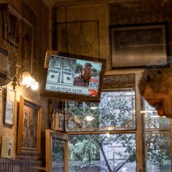 A television broadcasts financial news at a shoe-shine shop in Buenos Aires on April 14, after Javier Milei’s government eased currency controls in Argentina.