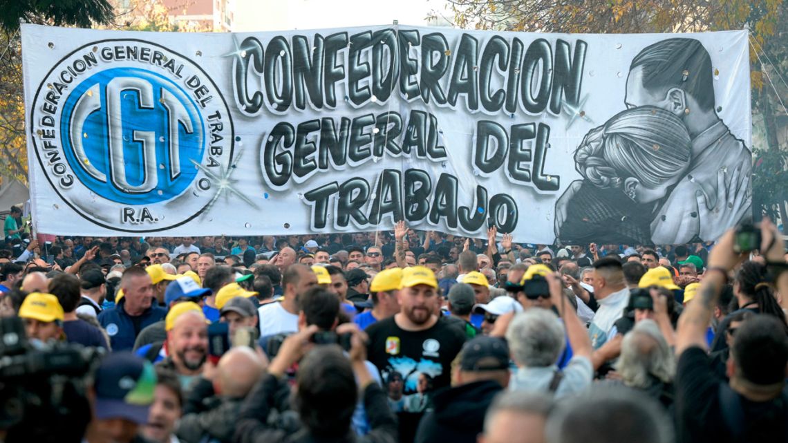 A banner from the General Confederation of Labour (CGT) umbrella union grouping is displayed by workers during a rally against the government of President Javier Milei and to commemorate May Day (Labour Day) in Buenos Aires on April 30, 2025. Argentina's labor unions mobilized on Wednesday on the eve of Workers' Day with slogans against the austerity measures of President Javier Milei. 