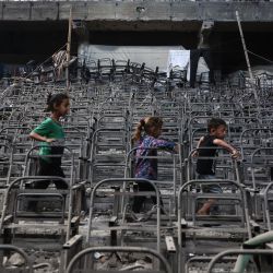 Niños palestinos desplazados juegan en un aula dañada en el campus de la Universidad Islámica de la Ciudad de Gaza. | Foto:OMAR AL-QATTAA / AFP