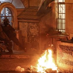 Un miembro de las fuerzas de seguridad israelíes empuja a un hombre durante una protesta contra el Estado de Israel organizada por miembros de Neturei Karta, una organización internacional de judíos ortodoxos antisionistas que, según ellos, no debería existir antes de la llegada del Mesías, en Jerusalén, coincidiendo con la celebración del 77.º Día de la Independencia de Israel. | Foto:AHMAD GHARABLI / AFP