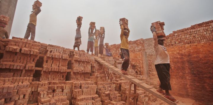 Imagen de personas trabajando en una fábrica de ladrillos, en Dhaka, Bangladesh.
