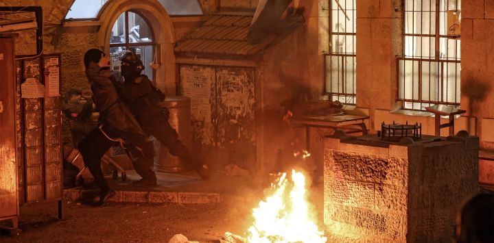 Un miembro de las fuerzas de seguridad israelíes empuja a un hombre durante una protesta contra el Estado de Israel organizada por miembros de Neturei Karta, una organización internacional de judíos ortodoxos antisionistas que, según ellos, no debería existir antes de la llegada del Mesías, en Jerusalén, coincidiendo con la celebración del 77.º Día de la Independencia de Israel.