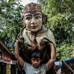 Un hombre carga un títere ondel-ondel preparándose para una actuación en Yakarta. Los ondel-ondel son títeres tradicionales gigantes de la cultura Betawi de Yakarta, originalmente utilizados en rituales y desfiles festivos para ahuyentar a los malos espíritus. | Foto:Yasuyoshi Chiba / AFP