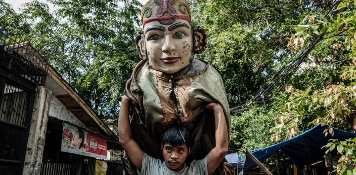 Un hombre carga un títere ondel-ondel preparándose para una actuación en Yakarta. Los ondel-ondel son títeres tradicionales gigantes de la cultura Betawi de Yakarta, originalmente utilizados en rituales y desfiles festivos para ahuyentar a los malos espíritus.