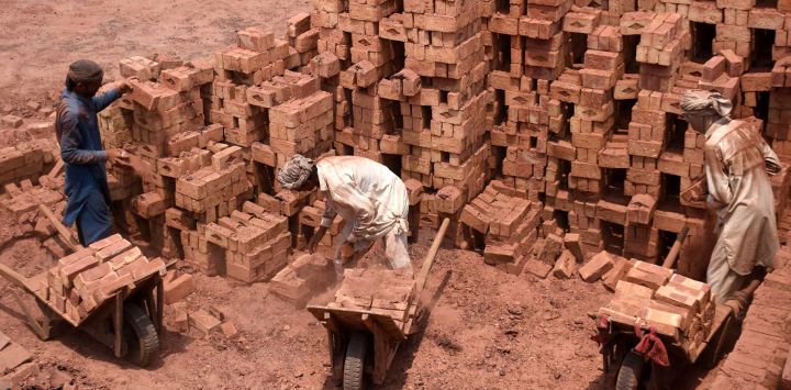 Trabajadores laboran en un horno de ladrillos, en Lahore, Pakistán.