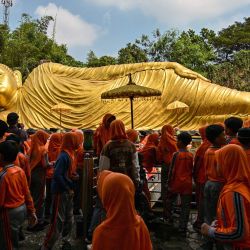 Estudiantes de un internado islámico visitan la estatua del Buda reclinado en el templo Maha Vihara Mojopahit en Mojokerto, provincia de Java Oriental, para conocer la diversidad cultural y religiosa de Indonesia antes del festival de Vesak, que conmemora el nacimiento, la iluminación y la muerte de Buda. | Foto:JUNI KRISWANTO / AFP