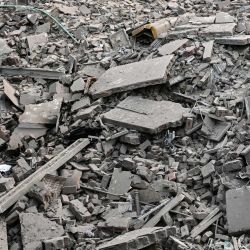 Residentes locales permanecen sobre los escombros de las estructuras destruidas en el complejo gubernamental de salud y educación en Muridke, a unos 30 kilómetros de Lahore, tras los ataques indios. | Foto:Farooq Naeem / AFP
