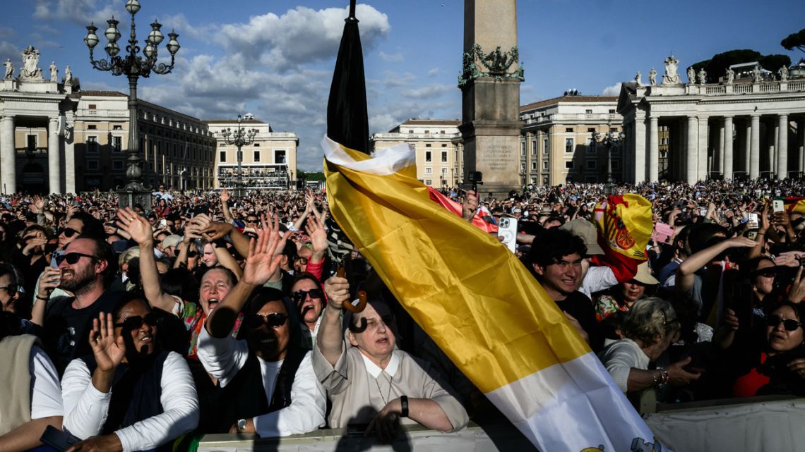 People react after white smoke rose from the chimney of the Sistine Chapel signalling that cardinals elected a new pope during their secret conclave, at Saint Peter's Square in The Vatican, on May 8, 2025. 