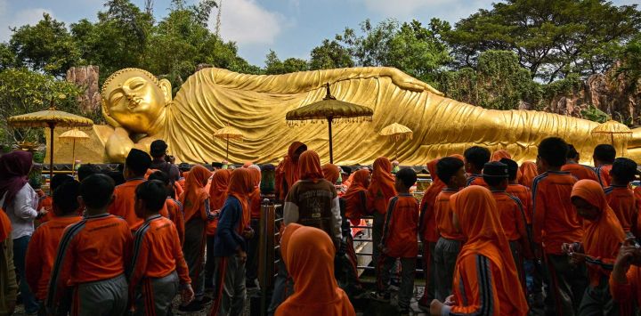 Estudiantes de un internado islámico visitan la estatua del Buda reclinado en el templo Maha Vihara Mojopahit en Mojokerto, provincia de Java Oriental, para conocer la diversidad cultural y religiosa de Indonesia antes del festival de Vesak, que conmemora el nacimiento, la iluminación y la muerte de Buda.