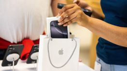 An employee bags a new iPhone smartphone for a customer at an Apple Store in London