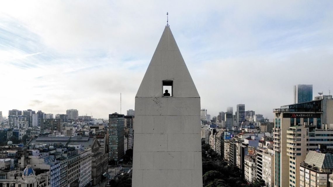 Aerial view showing a man looking down from the Obelisk observation deck in Buenos Aires on May 8, 2025. Buenos Aires' iconic Obelisk, a 67.5-meter monument that is the scene of Argentina's great celebrations, debuts a tourist elevator that will allow visitors and locals to access its summit with ease for the first time since its construction in 1936. 