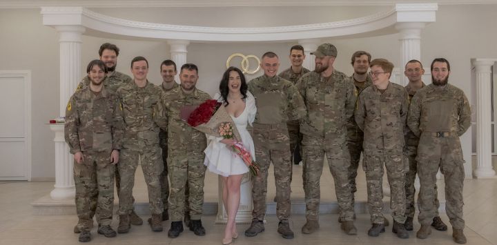 Anna, novia, y su novio, Pavlo Chornobai, militar ucraniano de la Brigada Azov, posan para una foto con los compañeros soldados de Pavlo durante su ceremonia de boda en el registro civil de Sloviansk, región oriental de Donetsk, en medio de la invasión rusa de Ucrania. La guerra infundió urgencia al compromiso de las parejas de militares ucranianos, quienes no ven sentido en esperar una paz que parece un mero espejismo.