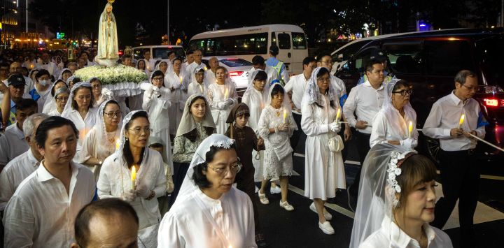 Los fieles siguen la procesión durante la festividad de Nuestra Señora de Fátima en Macao, China.