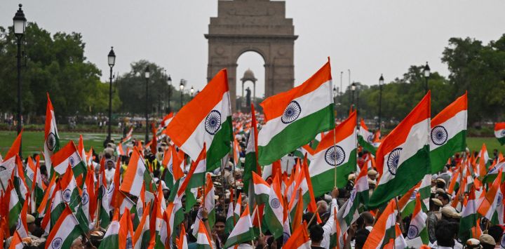 Personas ondeando banderas nacionales indias participan en una manifestación a lo largo del sendero Kartavya, cerca de la Puerta de la India, en solidaridad con las fuerzas armadas en Nueva Delhi, tras el alto el fuego entre Pakistán y la India.