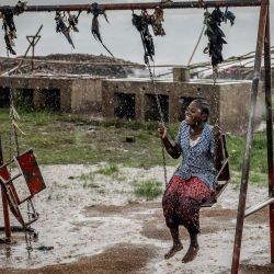 Un joven refugiado congoleño juega en un columpio bajo una intensa lluvia mientras esperan su reubicación en el Centro de Tránsito de Cishemere, cerca de Buganda. | Foto:LUIS TATO / AFP