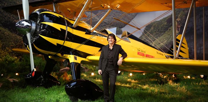 El actor estadounidense Tom Cruise posa en la alfombra roja junto a un avión a su llegada al estreno mundial de "Misión: Imposible - El Ajuste de Cuentas" en los Jardines de Leicester Square, en el centro de Londres.
