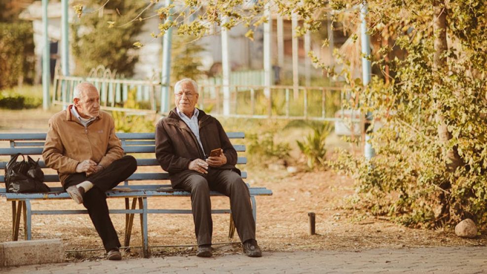 Ancianos sentados en un banco de la plaza