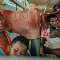 Dos personas desplazadas, presuntamente de nacionalidad ruandesa, se encuentran sentadas en un gran autobús con sus hijos tras ser inspeccionadas en la frontera entre la República Democrática del Congo y Ruanda, en Goma. | Foto:Jospin Mwisha / AFP