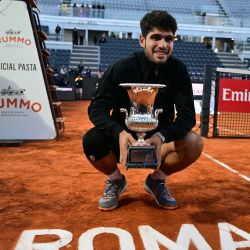 El español Carlos Alcaraz posa con su trofeo de campeón al final de su partido individual masculino contra el italiano Jannik Sinner por el torneo de tenis ATP Roma Open en el Foro Itálico de Roma. | Foto:Tiziana Fabi / AFP