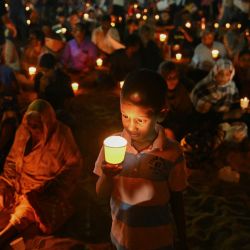 Personas con velas asisten a una ceremonia conmemorativa en honor a las víctimas de la Masacre de Mullivaikkal, en conmemoración del 16.º aniversario del Día del Recuerdo del Genocidio Tamil, en la playa Edward Elliot de Chennai. | Foto:R. Satish Babu / AFP
