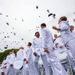 Oficiales recién comisionados lanzan sus sombreros durante la 144.ª ceremonia de graduación de la Academia de la Guardia Costera de EE. UU. en New London, Connecticut. | Foto:Joseph Prezioso / AFP