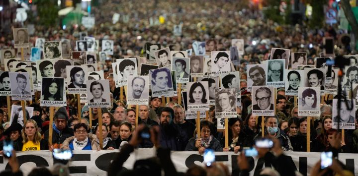 Imagen de personas sosteniendo pancartas durante la Marcha del Silencio, en Montevideo, capital de Uruguay. Decenas de miles de personas participaron de la trigésima Marcha del Silencio que recorrió en la noche el centro de Montevideo en reclamo de verdad y justicia por los detenidos-desaparecidos durante el régimen militar (1973-1985) de Uruguay.