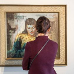 Bina Genovese, Subastadora Sénior de Desarrollo de Negocios y Marketing de Strauss&Co, observa la pintura "Dama de Oriente" del pintor ruso Vladimir Tretchikoff en Johannesburgo, antes de una subasta. | Foto:Wikus de Wet / AFP