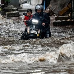 Un hombre empuja su motocicleta por una calle inundada tras las fuertes lluvias en Mumbai. Las fuertes lluvias anegaron Mumbai, la capital financiera de la India, cuando el monzón anual llegó unas dos semanas antes de lo habitual, según los meteorólogos. | Foto:PUNIT PARANJPE / AFP