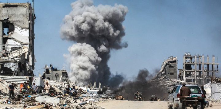 La gente observa las columnas de humo tras un ataque israelí en Jabalia, en el norte de la Franja de Gaza. Los rescatistas en Gaza informaron que 22 personas murieron y decenas resultaron heridas en ataques aéreos israelíes en territorio palestino.