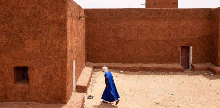 Un fiel musulmán entra en la mezquita antes de la oración del mediodía en Oualata. Oualata forma parte de un cuarteto de antiguas ciudades fortificadas o "ksour", declaradas Patrimonio de la Humanidad por la UNESCO. En su apogeo fueron centros comerciales y religiosos y ahora albergan joyas que datan de la Edad Media.
