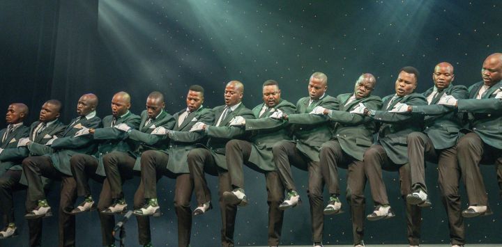 Un grupo tradicional Isicathamiya baila mientras interpreta una canción en el escenario durante la edición 2025 del Concierto Isicathamiya en el Teatro Natal Playhouse de Durban.