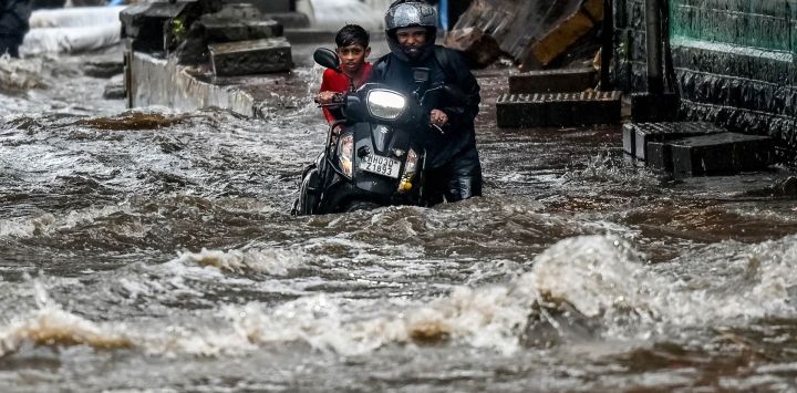Un hombre empuja su motocicleta por una calle inundada tras las fuertes lluvias en Mumbai. Las fuertes lluvias anegaron Mumbai, la capital financiera de la India, cuando el monzón anual llegó unas dos semanas antes de lo habitual, según los meteorólogos.