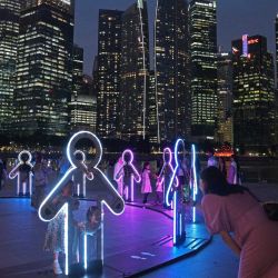Personas observan una instalación de luz durante la vista previa del espectáculo de luces "Ilumino Singapur", en el área de Marina Bay de Singapur. | Foto:Xinhua/Then Chih Wey