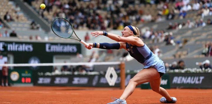 La eslovaca Rebecca Sramkova devuelve un revés a la polaca Iga Swiatek durante su partido individual femenino en la segunda jornada del Abierto de Francia, en la cancha Philippe-Chatrier del complejo Roland-Garros de París.