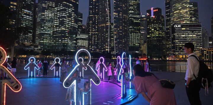 Personas observan una instalación de luz durante la vista previa del espectáculo de luces "Ilumino Singapur", en el área de Marina Bay de Singapur.