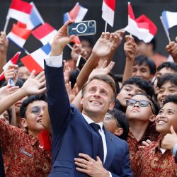 El presidente de Francia, Emmanuel Macron, posa para fotografías con estudiantes durante su visita a la Universidad Nacional de Yakarta, Indonesia. | Foto:Ludovic Marin / AFP