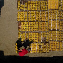 Vista aérea tomada con un dron de un trabajador colocando galletas amarillas tradicionales en platos de bambú previo a secarlas en un taller casero, en la aldea de Karadenan, en la regencia de Bogor, Java Occidental, Indonesia. | Foto:Xinhua/Yorri Farli