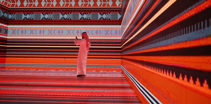 Imagen de un hombre observando un espectáculo de arte en pantallas interactivas durante una celebración organizada por la Sociedad Kuwaití Al-Sadu, en la Ciudad de Kuwait.